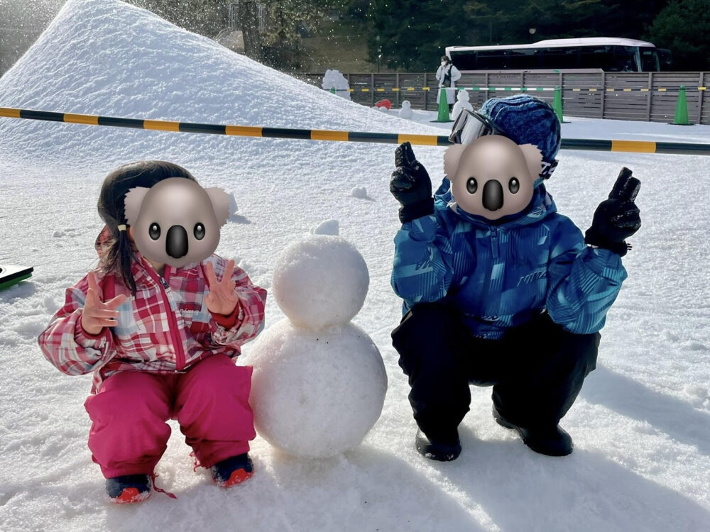 雪だるまとピースする兄妹