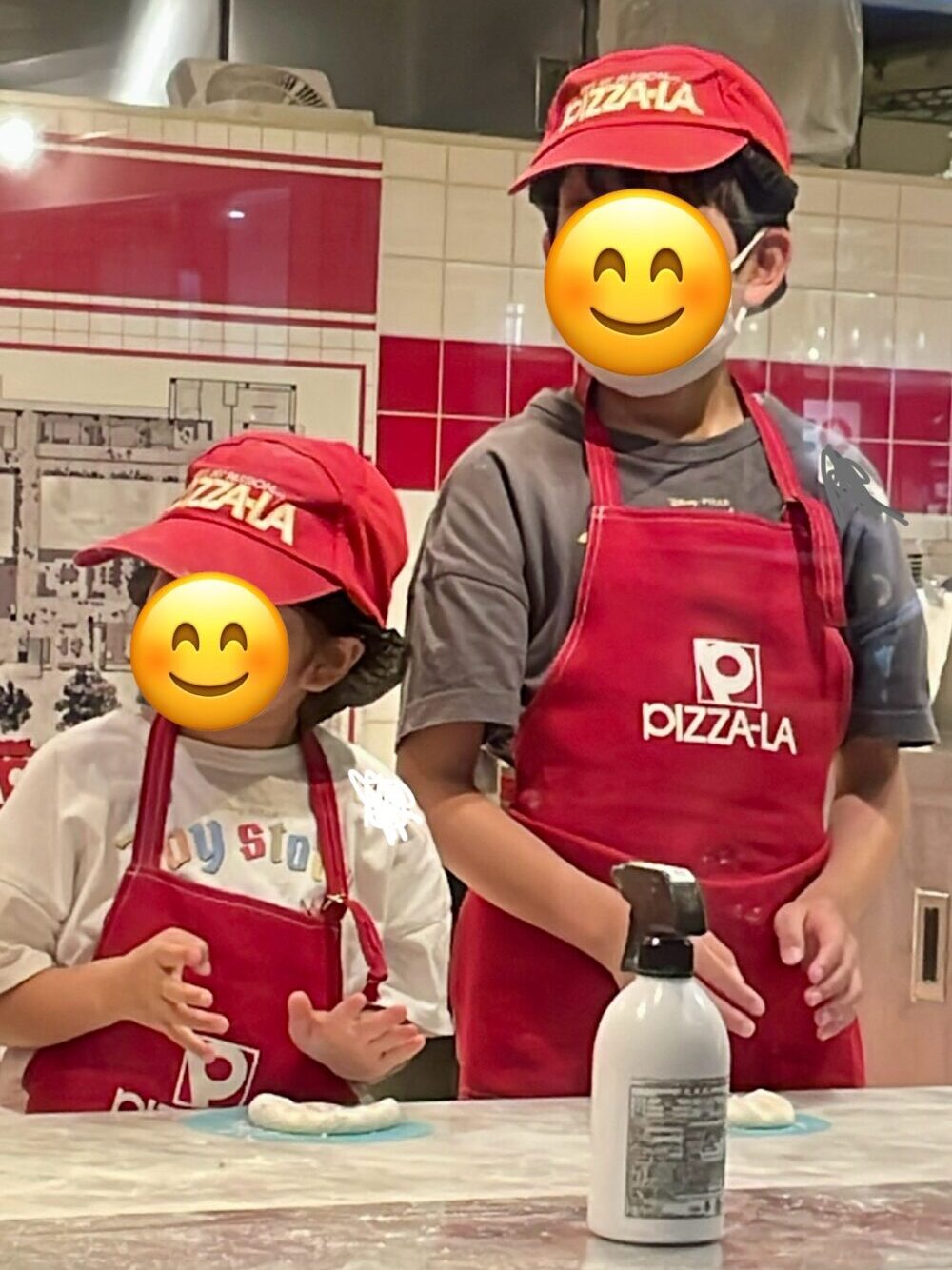 ピザの成形について説明を聞く兄妹