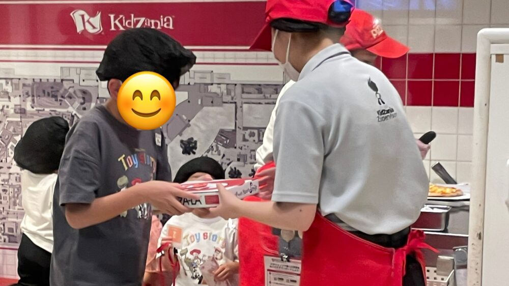 出来上がった自分のピザを受け取る兄